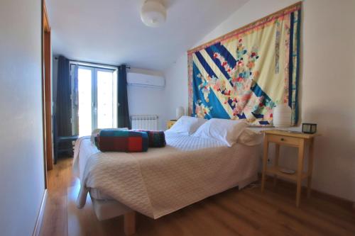 a bedroom with a bed with a painting on the wall at A Casa da Lena in Foz do Cobrão