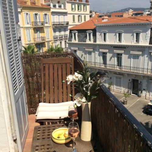 - un balcon avec une table et des verres de vin dans l'établissement Lecerf apartment, à Cannes