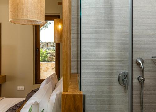 a bedroom with a shower with a glass door at Terra Lucis Mountain Residences in Agios Leon