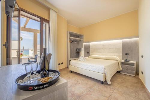ein Schlafzimmer mit einem Bett und einer Schüssel mit Essen auf einem Tisch in der Unterkunft Hotel Salento Mirfran in Torre San Giovanni Ugento