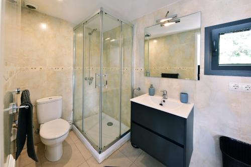 uma casa de banho com um chuveiro, um WC e um lavatório. em Dúplex Luminoso en el centro de CADAQUÉS em Cadaqués