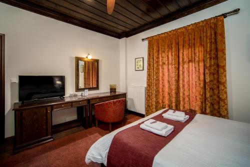 a hotel room with a bed and a desk and a television at Hotel Giamandes in Elati Trikalon
