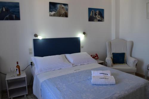 a bedroom with a large bed and two chairs at Andriani's Guest House in Mýkonos City
