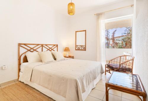 una camera con un letto e una sedia e una finestra di Del Mar Luxury Apartment 30m From The Beach a Porto Rafti