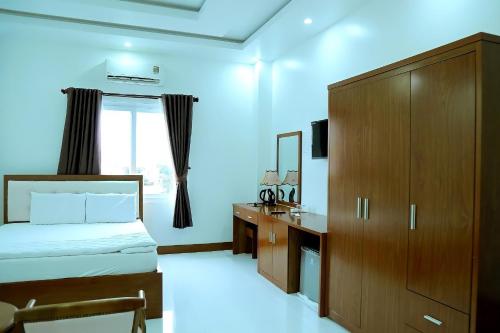 1 dormitorio con cama, tocador y espejo en HOTEL ĐĂNG KHOA 2 NÚI SAM en Chau Doc