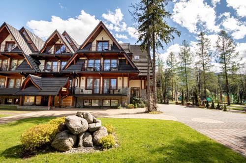 a large house with rocks in front of it at Hotel Willa Pod Skocznią in Zakopane