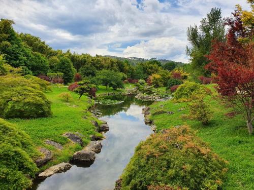 a river in the middle of a field with trees at La Bastide Bleue in Anduze