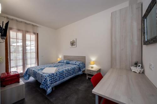 a bedroom with a bed and a red chair at Villa Michelangelo in Castellammare del Golfo