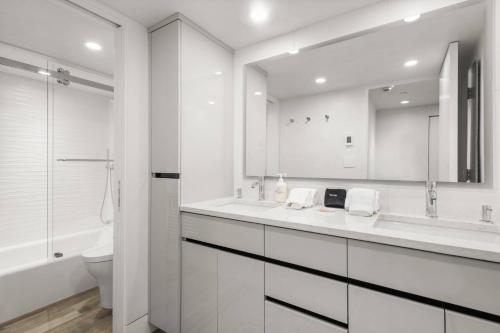 a bathroom with two sinks and a toilet and a mirror at Little Nell Condo #3 in Aspen