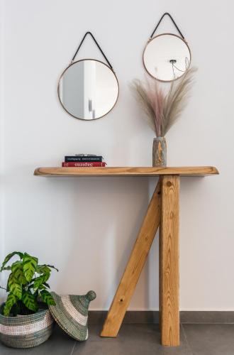 a wooden table with a mirror on the wall at Eclipse Tales in Adamas