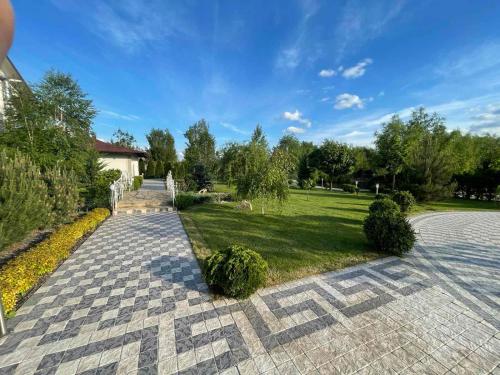 a brick walkway leading to a park with a lawn at Villa SAMSON in Căuşeni