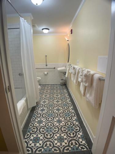 a bathroom with a bath tub, toilet and sink at Fort Conde Inn - Mobile in Mobile