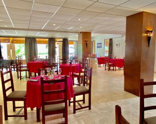 uma sala de jantar com mesas e cadeiras vermelhas em Hotel - Restaurant de la Paix em Barbotan-les-Thermes