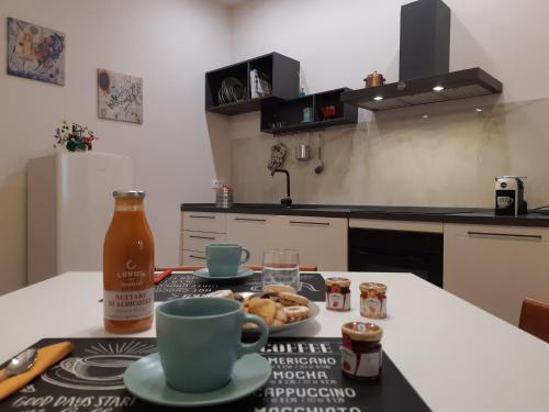 a kitchen with a table with two cups and a bottle at 7centro in Lastra a Signa