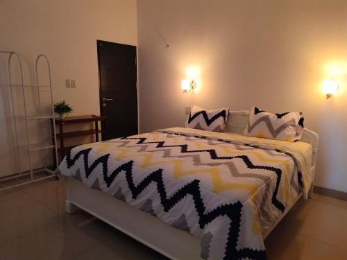 a bedroom with a bed with a black and white comforter at Tropical Cozy House in the heart of Medan in Medan
