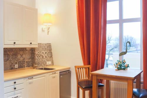 kuchnia ze stołem, umywalką i oknem w obiekcie Apartamenty Świnoujście - Armii Krajowej 11 w Świnoujściu