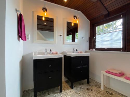 uma casa de banho com 2 lavatórios e um espelho em B&B Worpsweder Blick em Osterholz-Scharmbeck