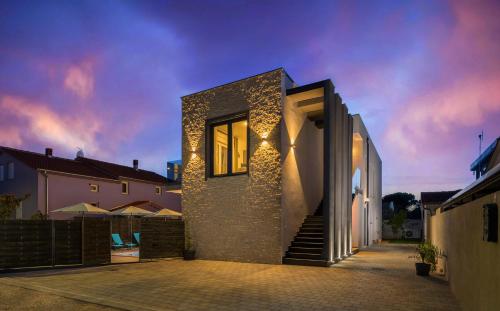 une maison avec une façade en pierre et des lumières sur elle dans l'établissement Valla Studio Apartments, à Fažana