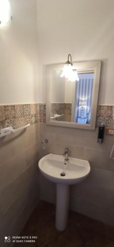 a bathroom with a white sink and a mirror at B&B Il Cardinale in Rocca di Mezzo