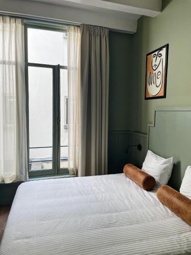 a bedroom with a bed with a large window at The Times Hotel in Amsterdam