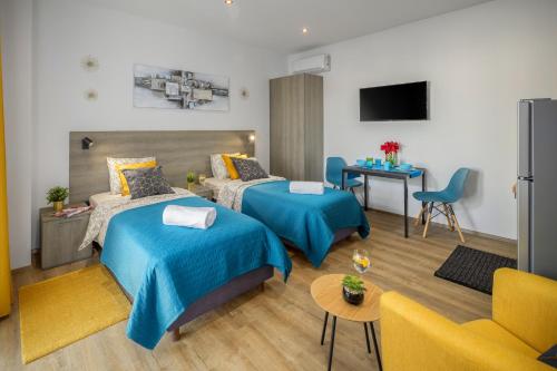 a hotel room with two beds and a couch at Valla Studio Apartments in Fažana