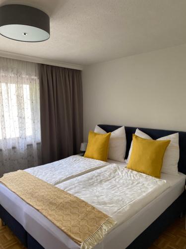 Apartment Ananas I Zentral & SeeNah في بويرشاك آم فورثيرسي: غرفة نوم بسرير كبير مع مخدات صفراء