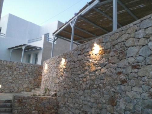 a stone wall with lights on the side of a building at Makares in Donoussa