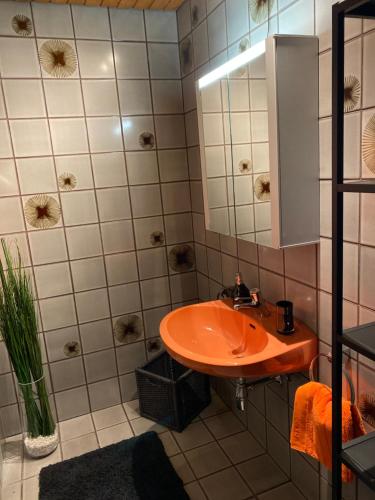 a bathroom with an orange sink and a mirror at Apartment Ananas I Zentral & SeeNah in Pörtschach am Wörthersee