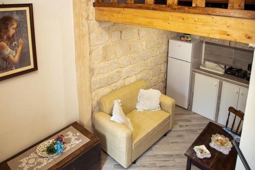 a living room with a couch and a kitchen at Anticu Dammusu 3 in Scicli