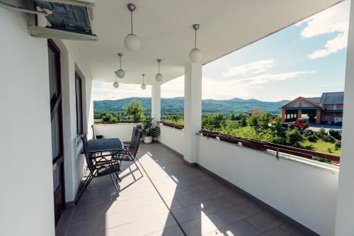 Frankovič Bed&Breakfast في Vinica: شرفة بها كراسي وإطلالة على الجبال
