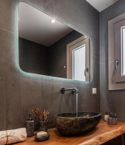 a bathroom with a stone sink and a mirror at Eclipse Tales in Adamas