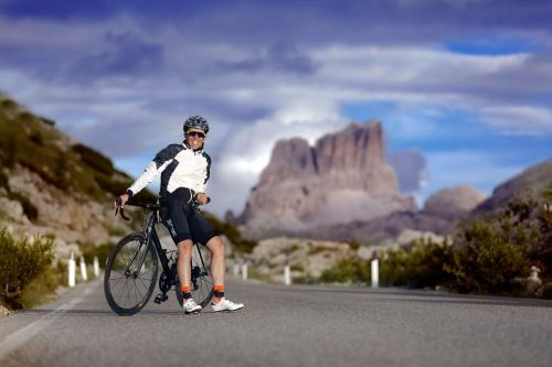 a man riding a bike down a road at Hotel Gran Paradiso in San Cassiano