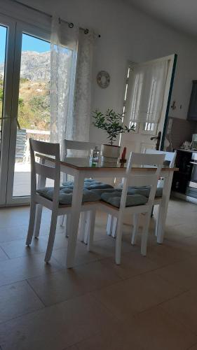 a white dining room table and chairs with a window at Avra Studios in Masouri