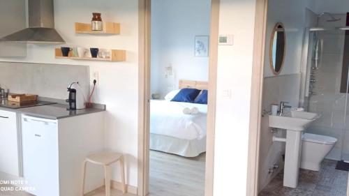 a bathroom with a sink and a toilet and a bed at Apartamentos El Respigu in Cangas de Onís