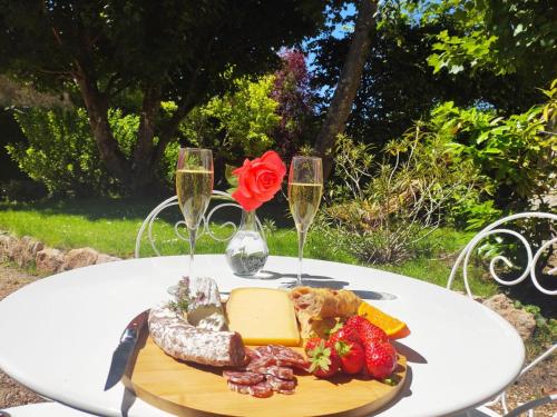 a table with a plate of food and two glasses of champagne at Les Charmilles in Amboise