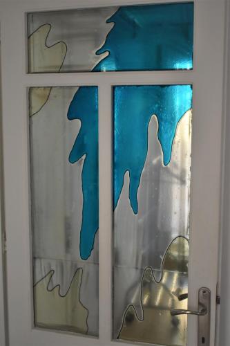 a glass window with blue paint on it at Manzara Apartment in Kaş