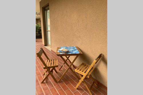 une table et deux chaises assises sur une terrasse dans l'établissement Lario Promenade: family friendly apartment in Como, à Côme