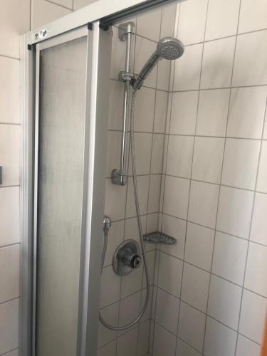 a shower with a shower head in a bathroom at Apartments by Haus Ingrid in Kötschach