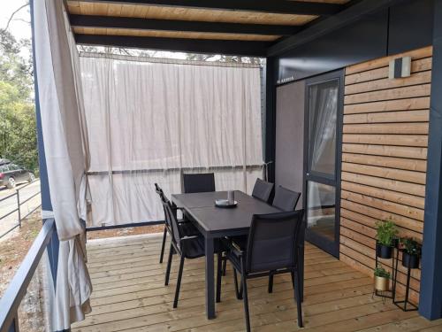 a patio with a table and chairs on a deck at Mobile Home Erna, Rovinj in Rovinj