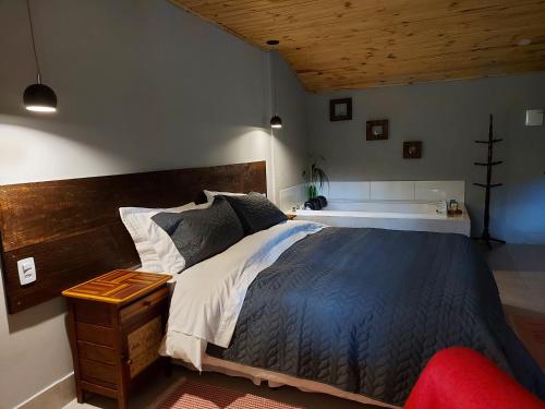 a bedroom with a large bed with a wooden headboard at Pousada Polessas in Visconde De Maua