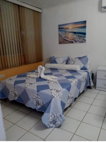 a bedroom with a bed with a blue and white blanket at Casa Peace Haven Beach House Aguada in Aguada