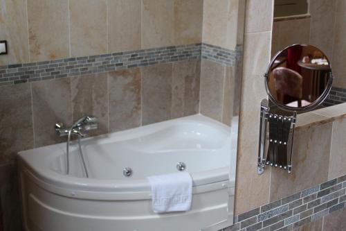 a bathroom with a bath tub with a mirror at ARTE Y NATURA VALDIVIELSO in Quintana de Valdivielso