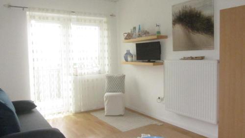 ein Wohnzimmer mit einem Sofa und einem Fenster in der Unterkunft Appartement am See in Podersdorf am See
