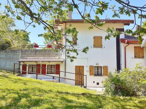 una casa bianca con porte rosse su una collina di Borgo Castelluccio Country House a Porretta Terme