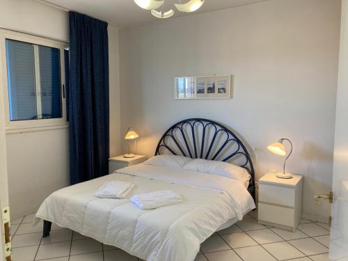 sypialnia z łóżkiem, 2 lampami i oknem w obiekcie Appartamento su Residence Paradiso Azzurro w mieście Porto Recanati