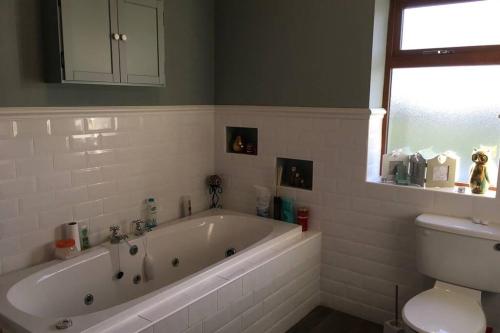a bathroom with a white tub and a toilet at Annies Meadow. in Knock