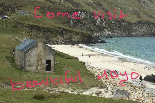 a building on a beach with the words come visit beautiful new zealadesh at Annies Meadow. in Knock