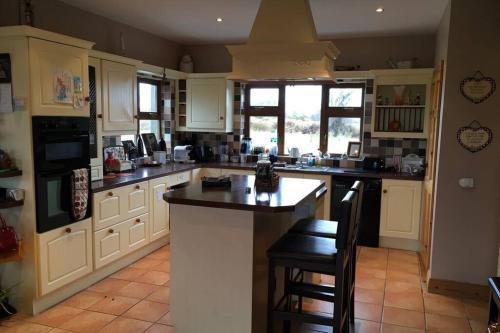 a kitchen with white cabinets and black counter tops at Annies Meadow. in Knock