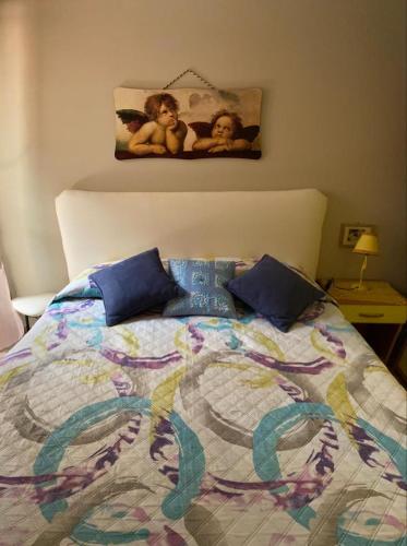 a bed with a colorful comforter with two babies on it at Balcone Eleonora in Cefalù
