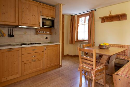 a kitchen with wooden cabinets and a wooden table at Villa Fridau resort in Gressoney-Saint-Jean